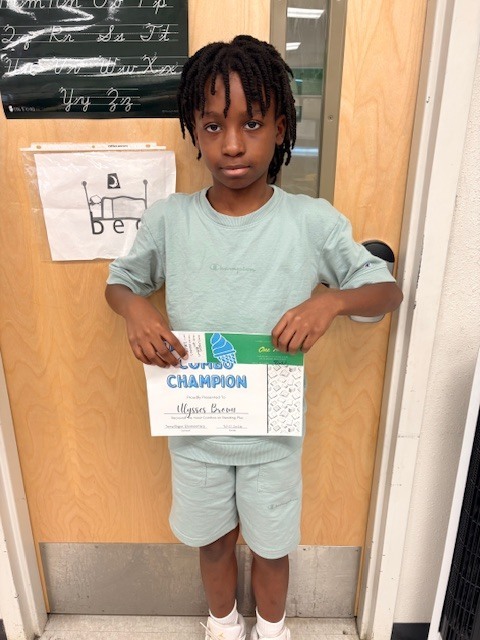 student in front of a door with a certificate