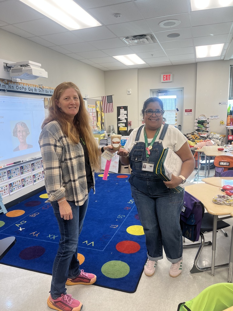 two women with coffee in a classroom