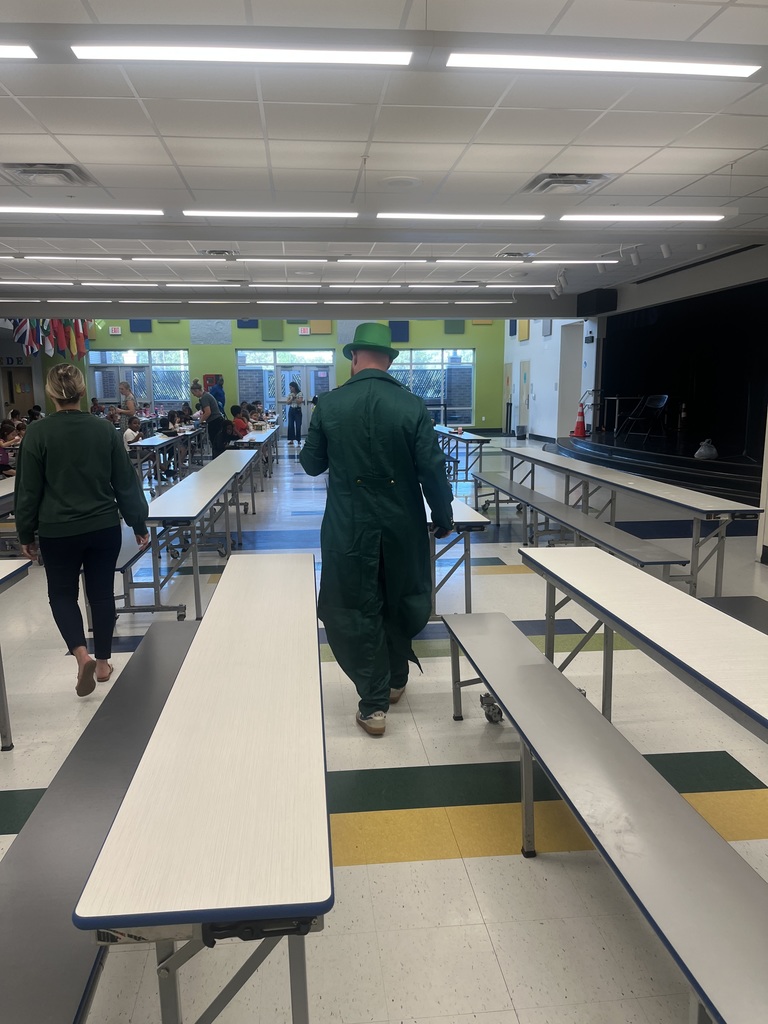 Mr Rutan in a leprechaun costume walking in the cafeteria