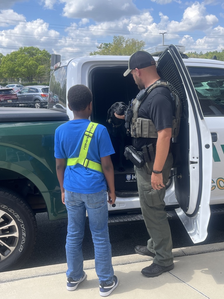 student and deputy at a truck with a k9 deputy