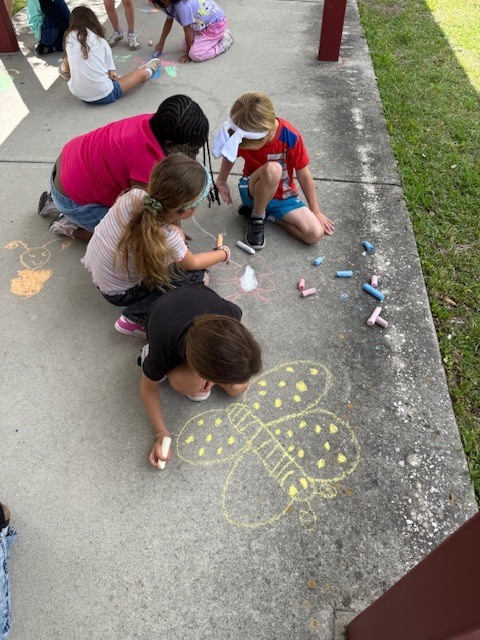 Friday Fun! Ms. Cecere's class enjoyed the sunshine with a picnic lunch bunch while Ms. Rucker's Kindergarten drew sidewalk chalk butterfly predictions based on their Science lesson.