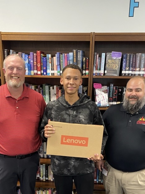 Coke Florida reps present a laptop to a student