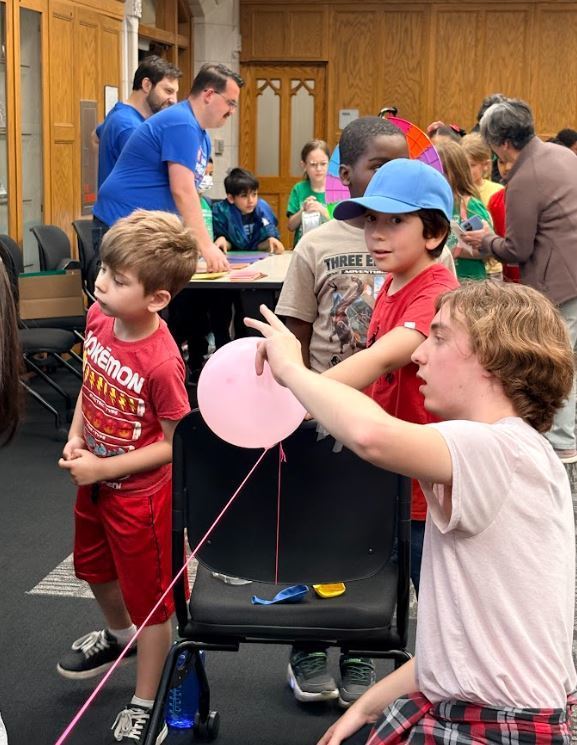 students using a balloon and string to conduct a science experiment