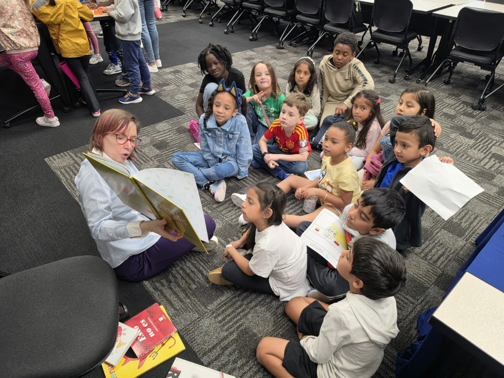 students on the carpet reading a story in Spanish