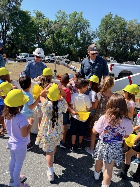 class in front of a bucket truck