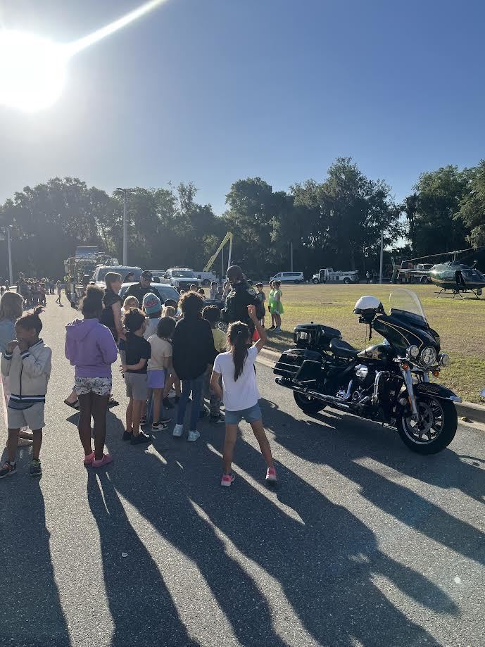 students in front of a police motor cycle
