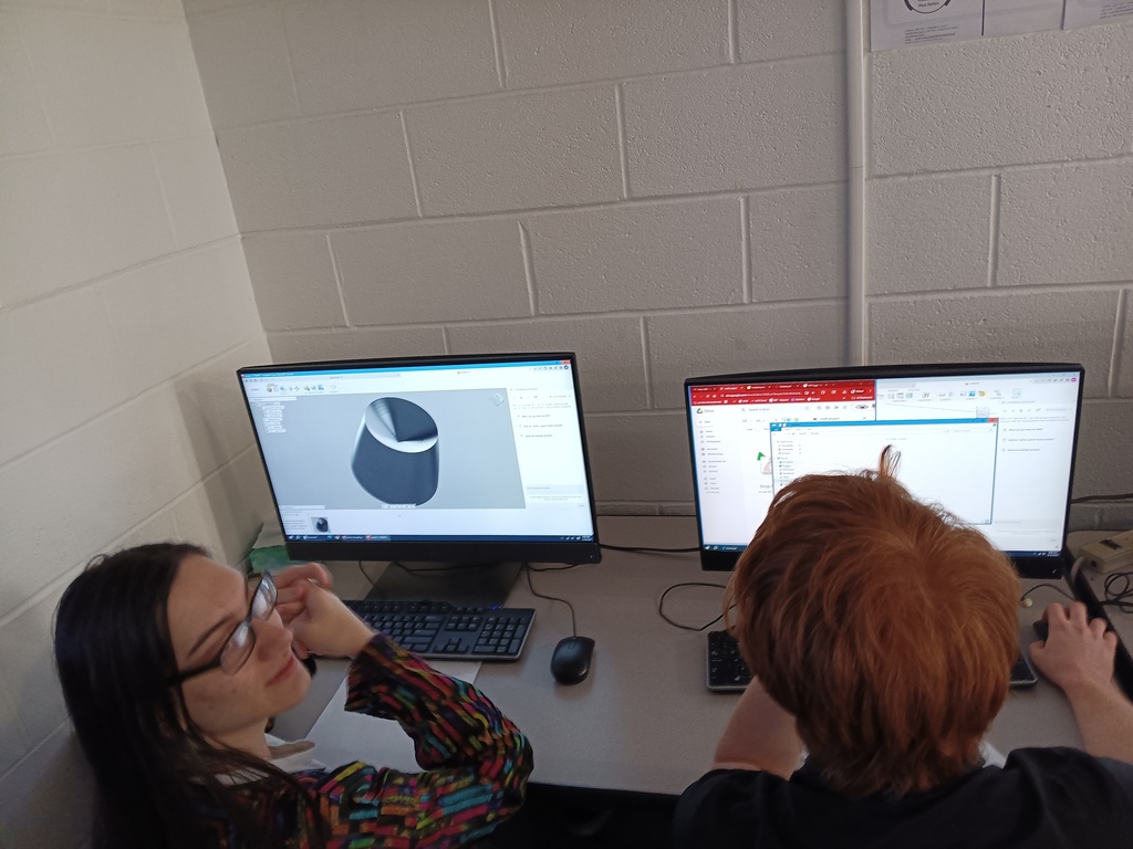 one student looks at a computer screen, another students looks up