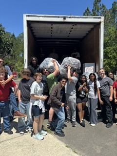 Students stand with bags of shoes