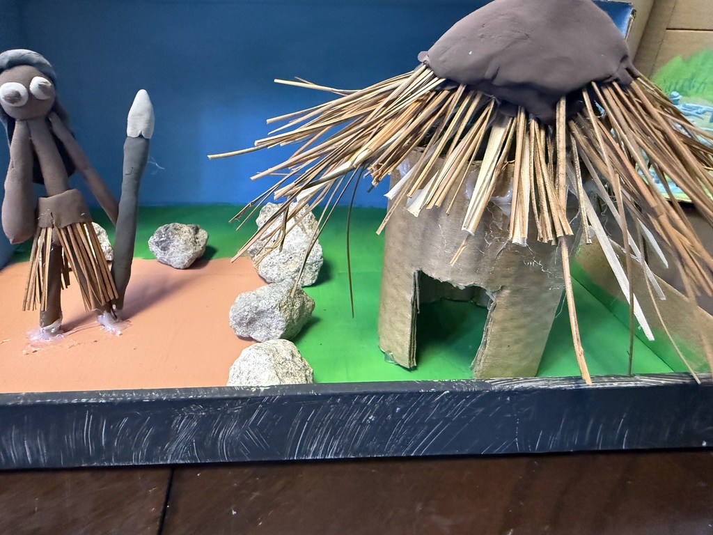 Native American Diorama with household objects depicting huts, water, hay, animals.
