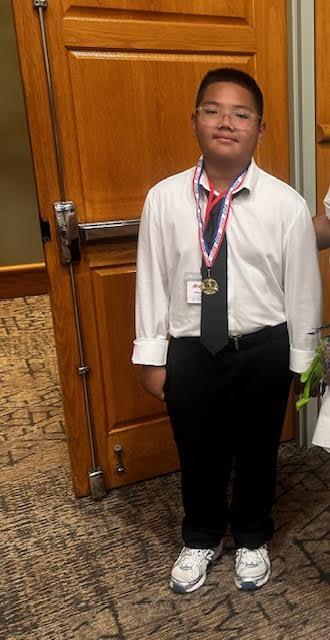 student in a tie with a medal on