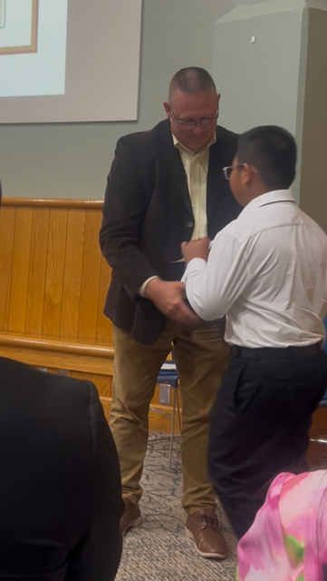 student shaking hands with a man