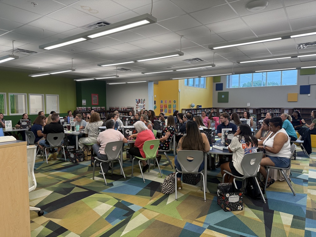 group of people sitting at tables in a library