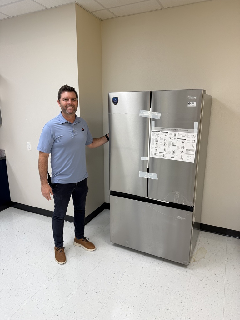 picture of a man in a blue shirt next to a silver fridge