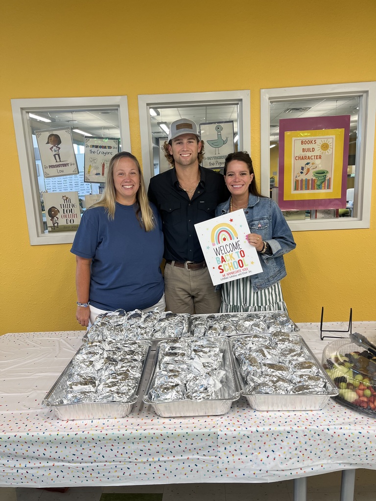 Three people posing in front of a table