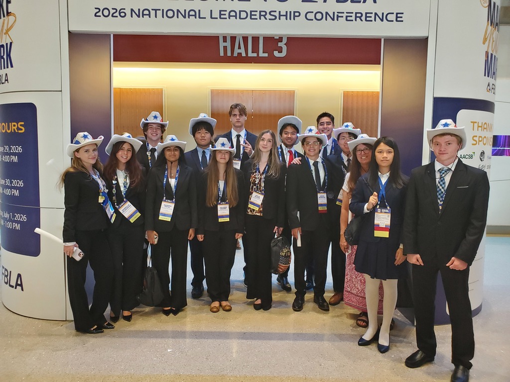 A group photo of students wearing cowboy hats.