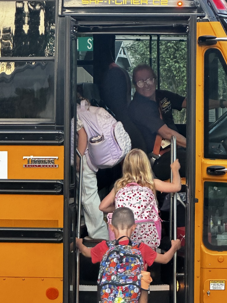 kids getting onto a school bus