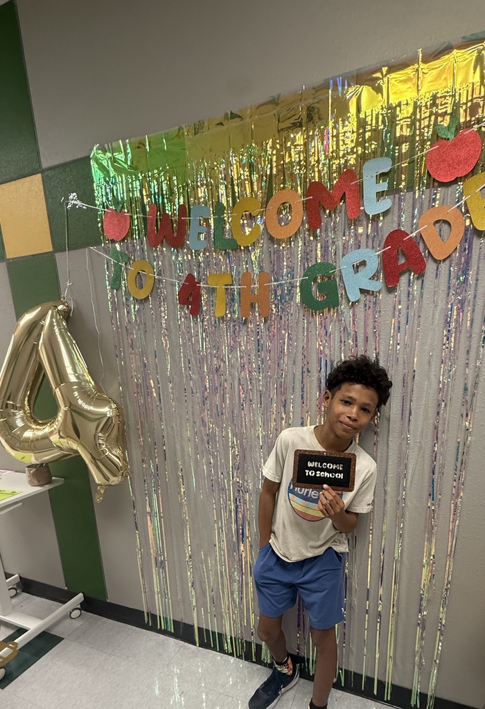 student smiling in front of banner