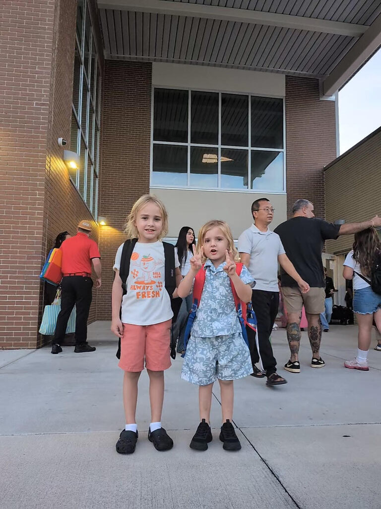 two boys smiling in front of school