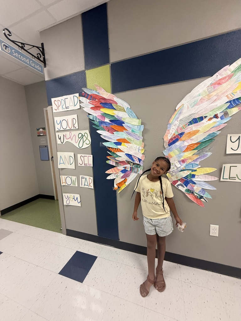 student smiling in front of wings