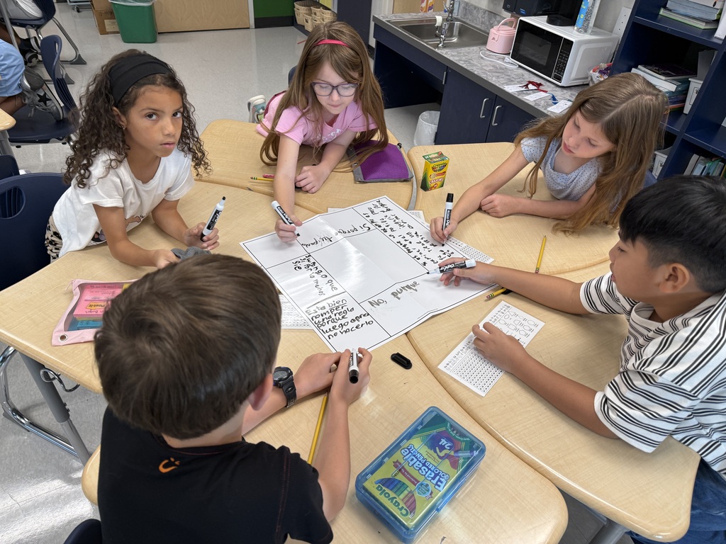 five students working at a desk