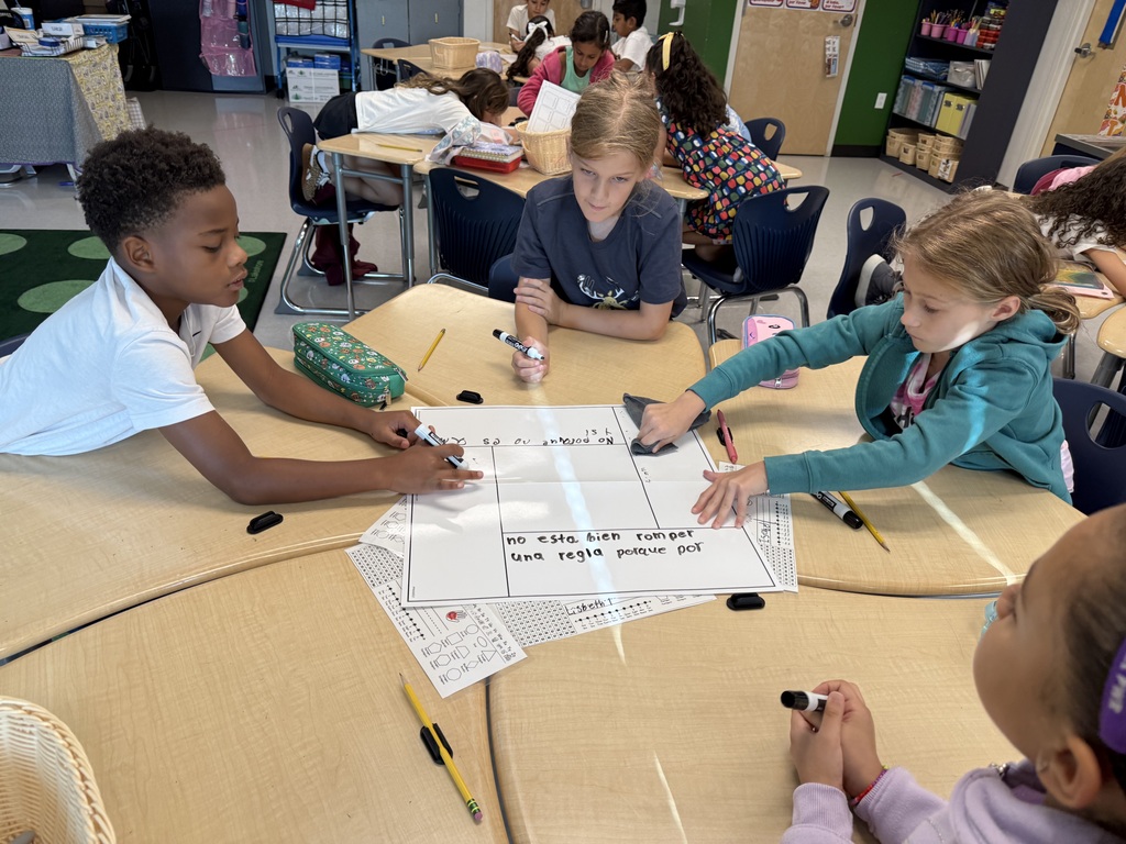 four students working at a desk