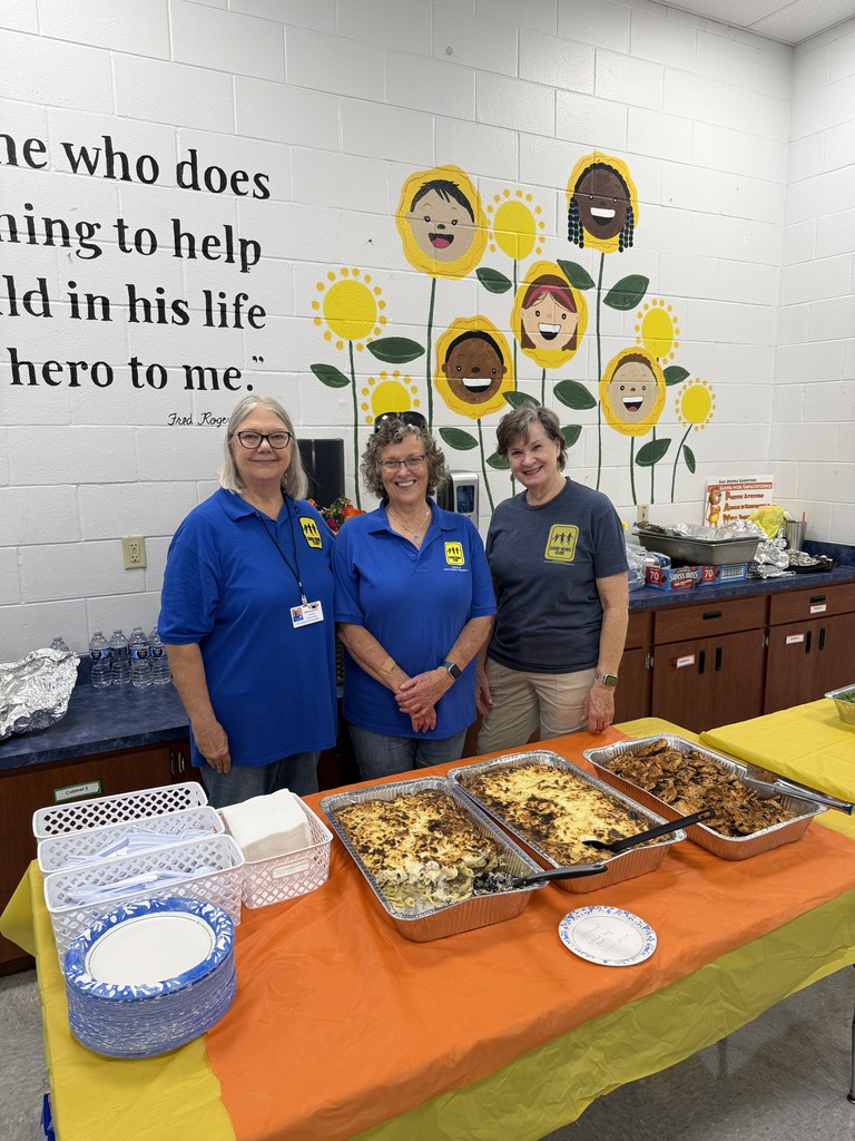 Three volunteers from Good News Club standing behind food brought for teachers.