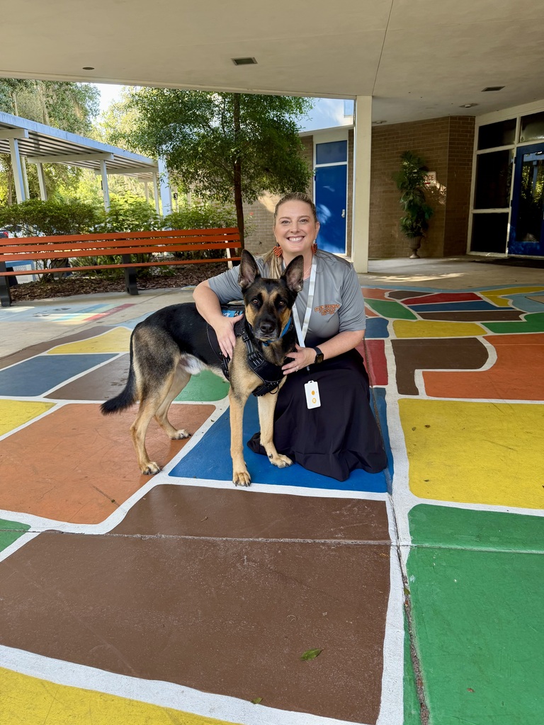 Photo shows Nox, the therapy and safety standing with the principal of Glen Springs Elementary school.