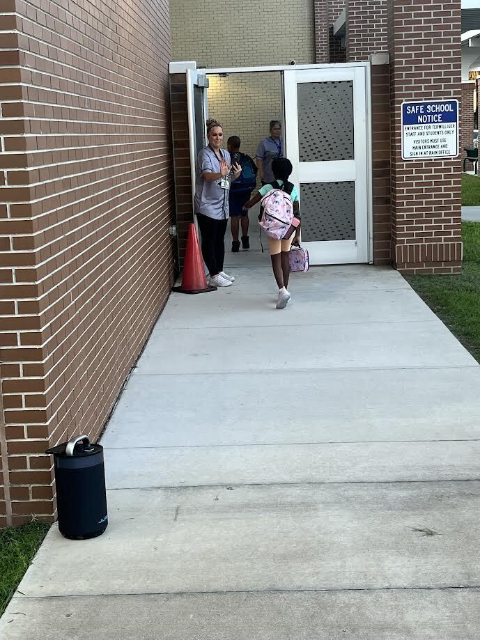 students walking into a brick building