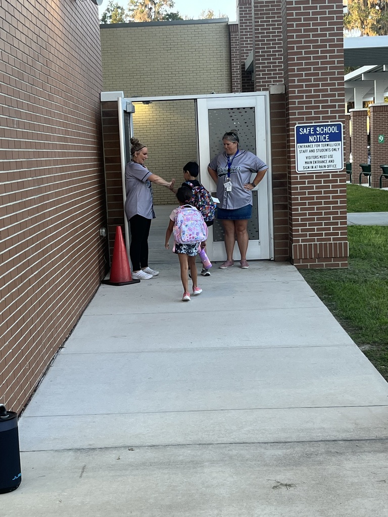 students walking into a brick building