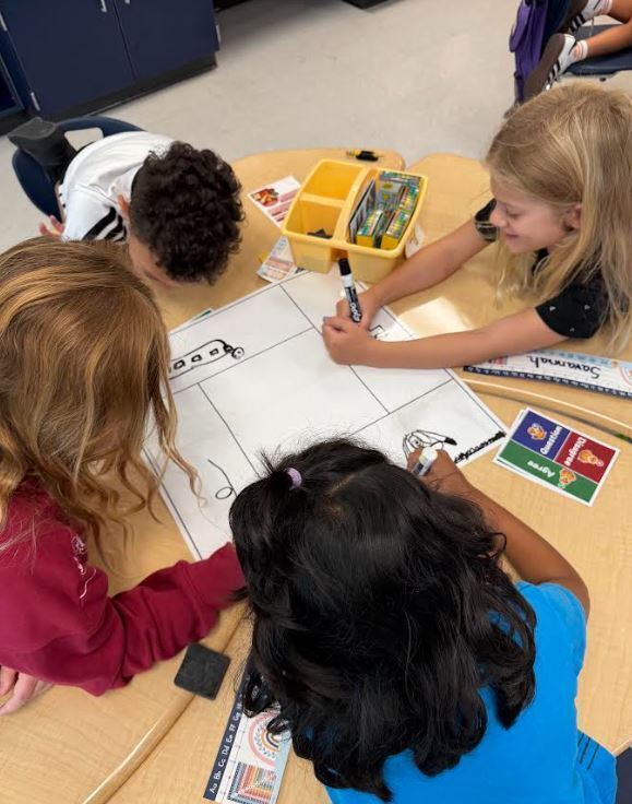 four students writing at desks
