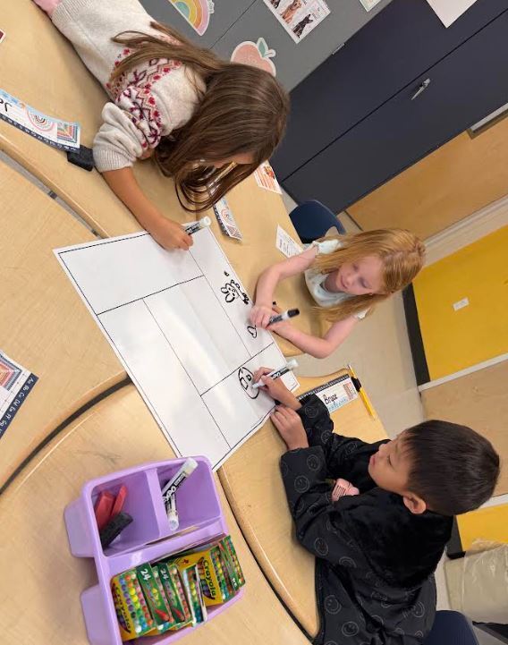 three students working at a desk