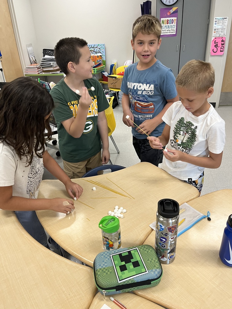 4 students with spaghetti and marshmallows