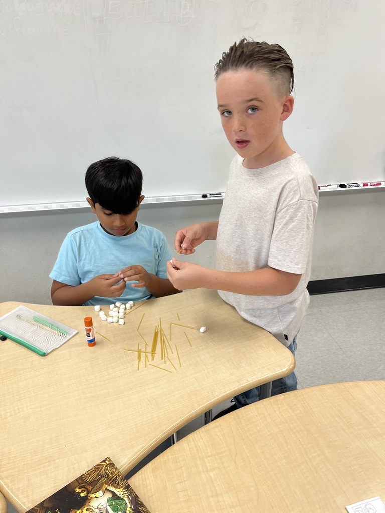 two students building with marshmallows