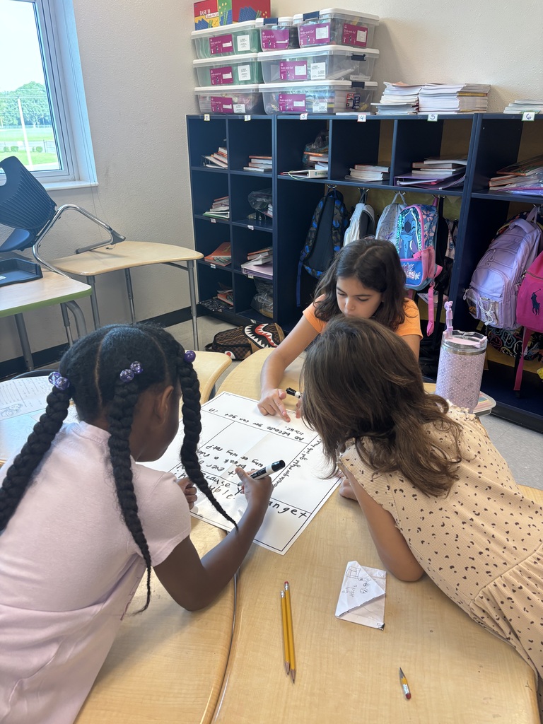 three students working at a desk