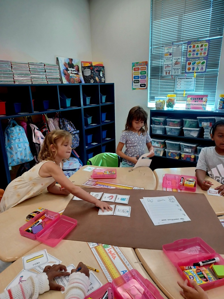three students working on a brown poster