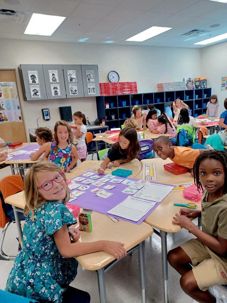 classroom of students working on purple posters