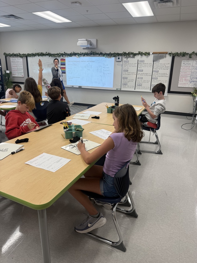 students sitting at tables solving math problems