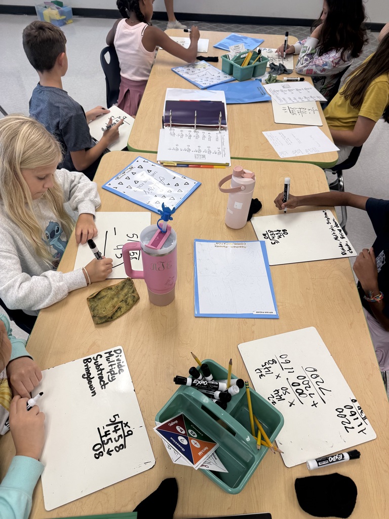 students sitting at tables solving math problems