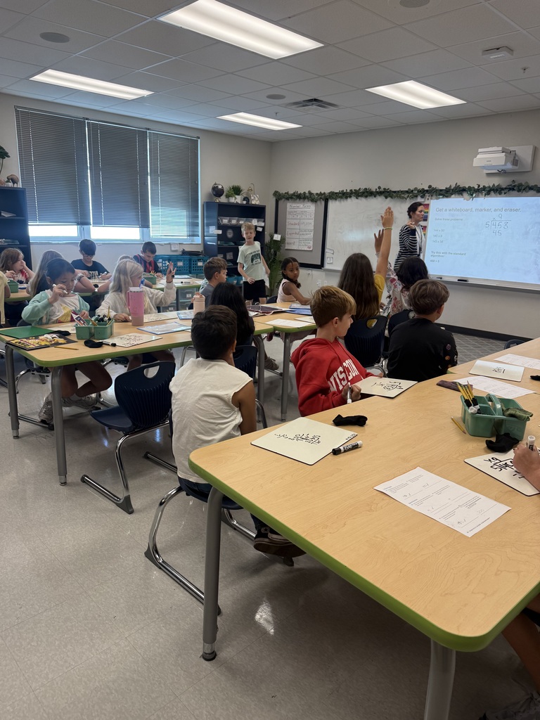 students sitting at tables solving math problems