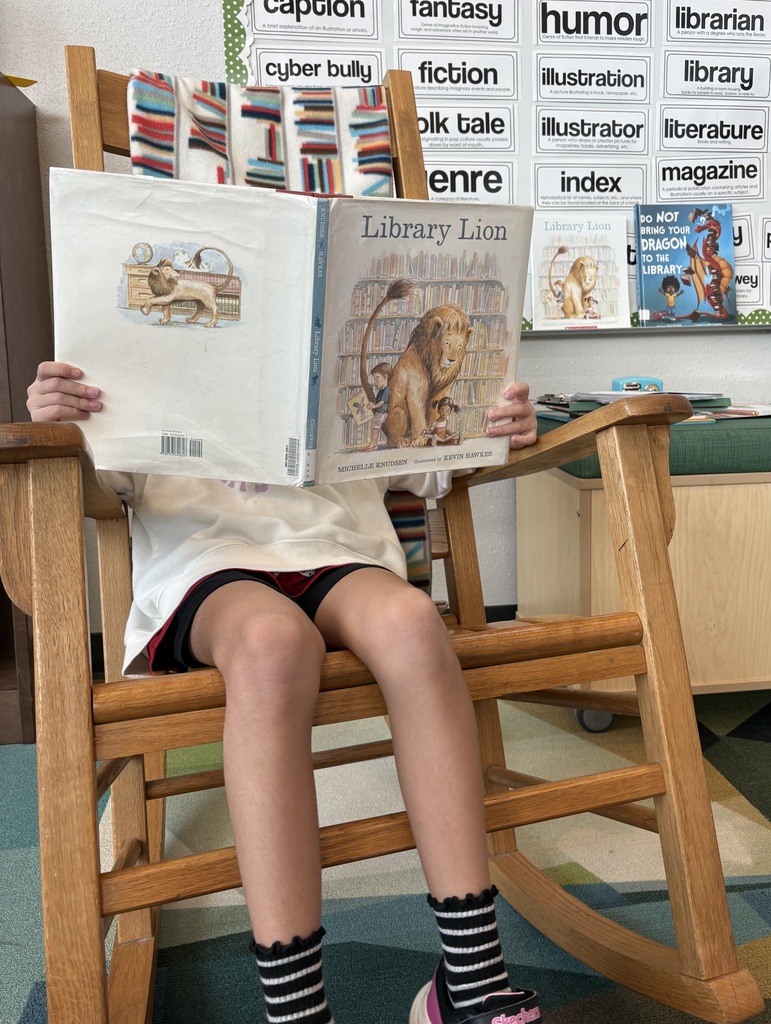 student in rocking chair reading the Library Lion book