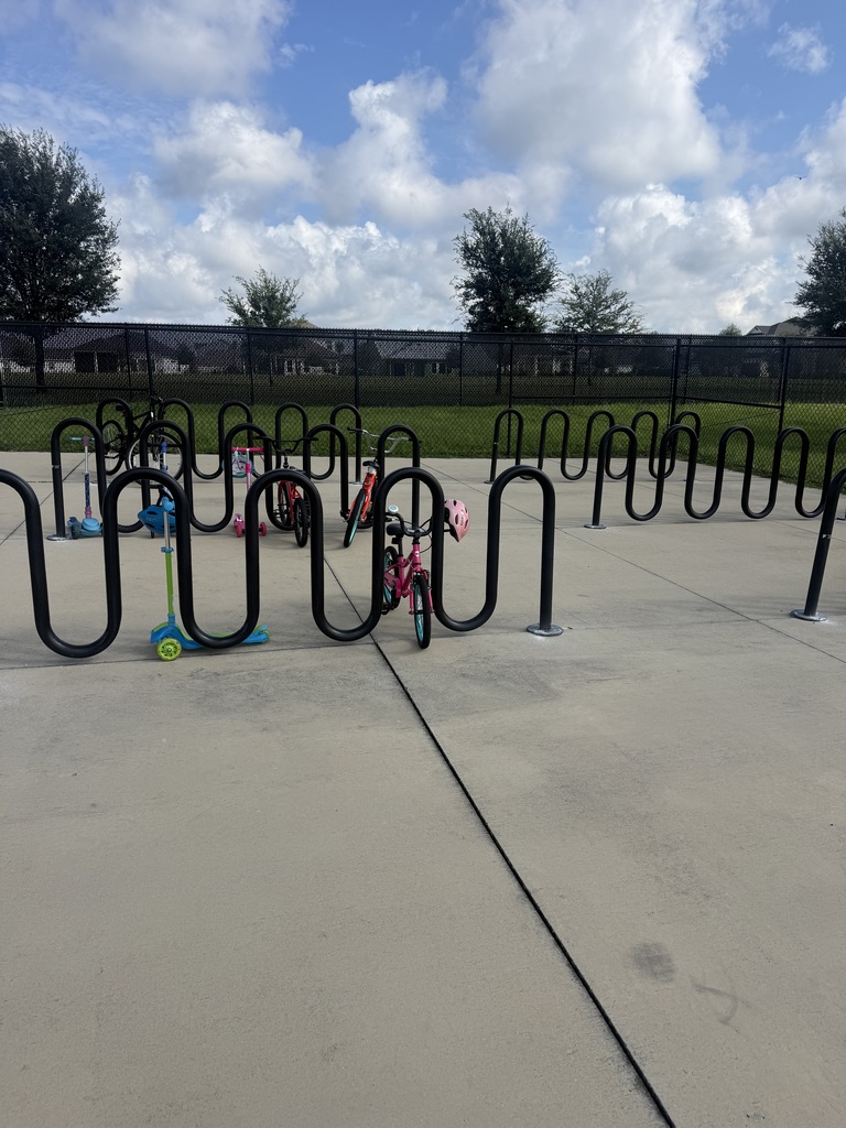 bike racks with bikes and scooters parked at it