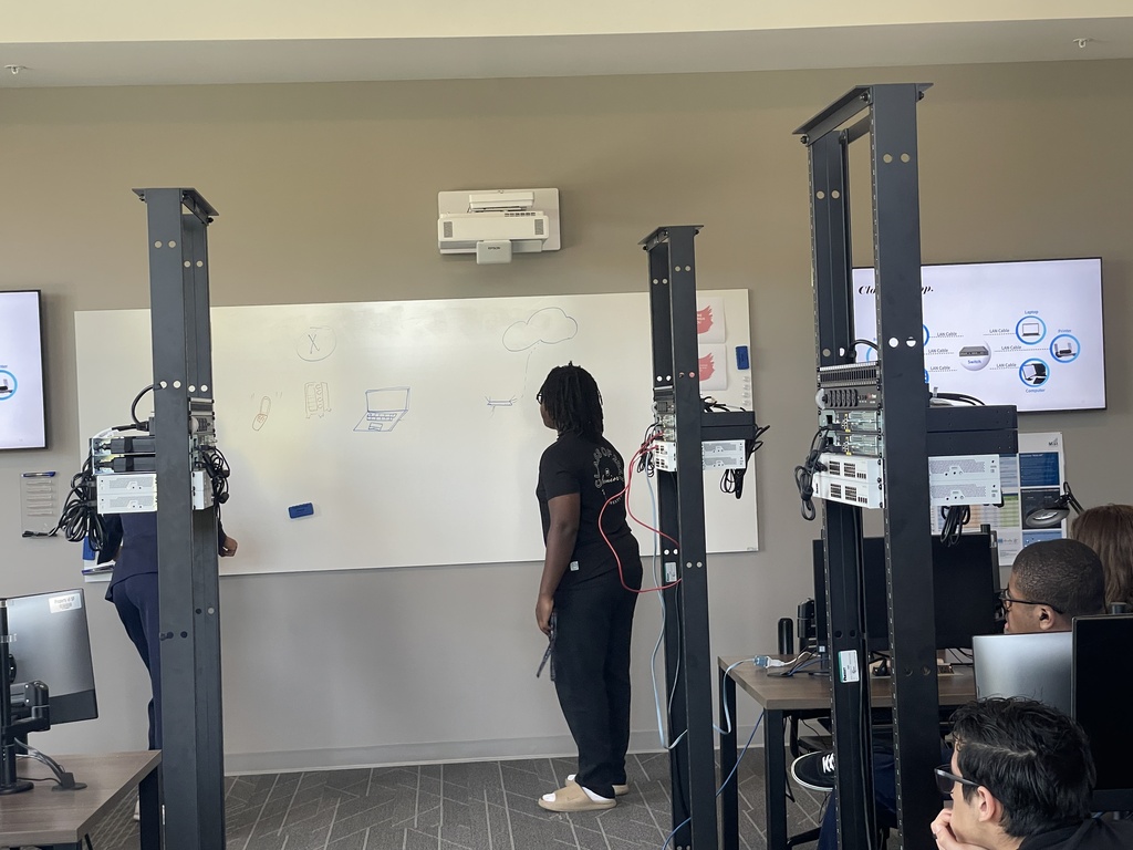 2 students stand in front of a dry erase board