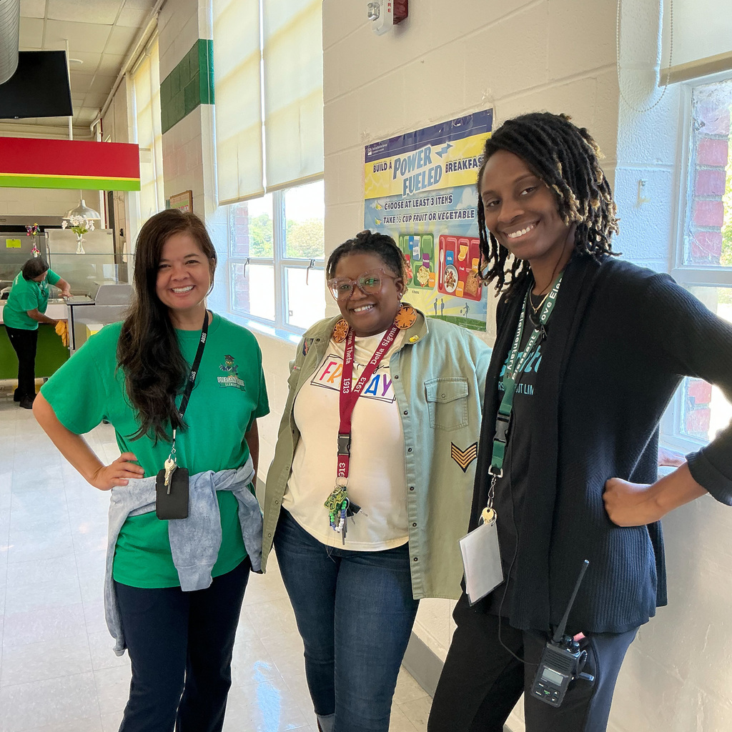 Staff at Pleasant Grove Elementary pose for a photo in a school cafeteria