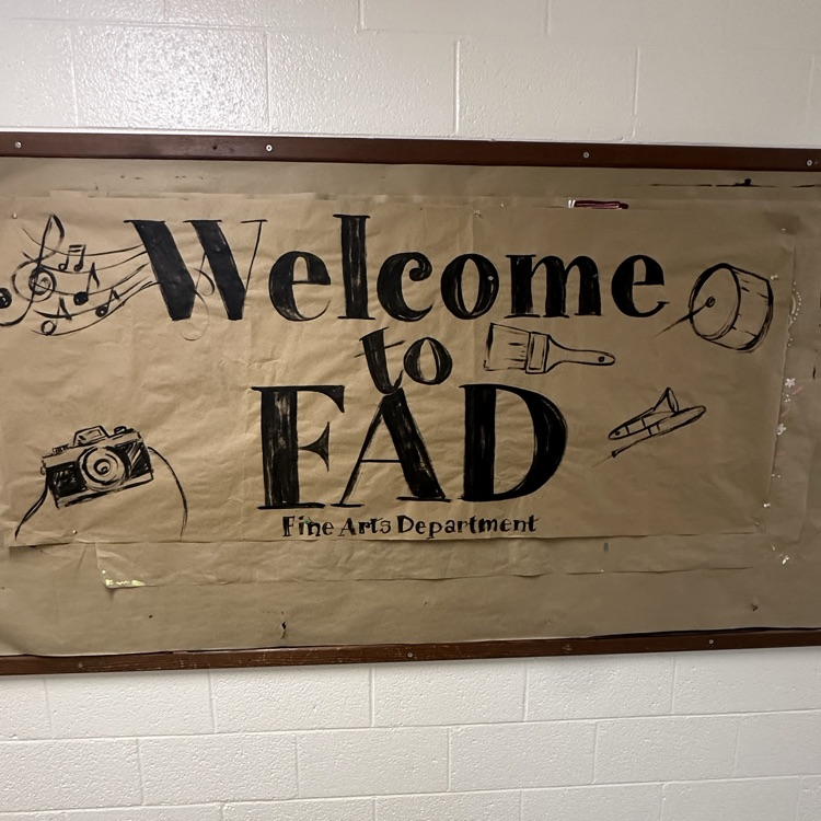 FAD bulletin board with butcher paper covering it with black writing and images of paint brushes and drums 
