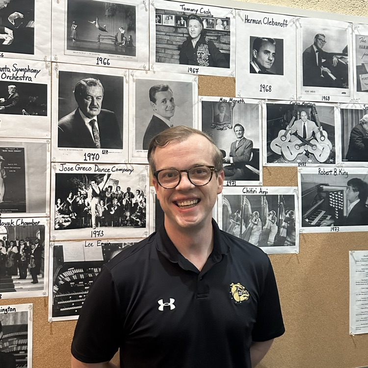 Mr Connor, Chorus Teacher, in front of billboard of famous performers from the WHS stage. 