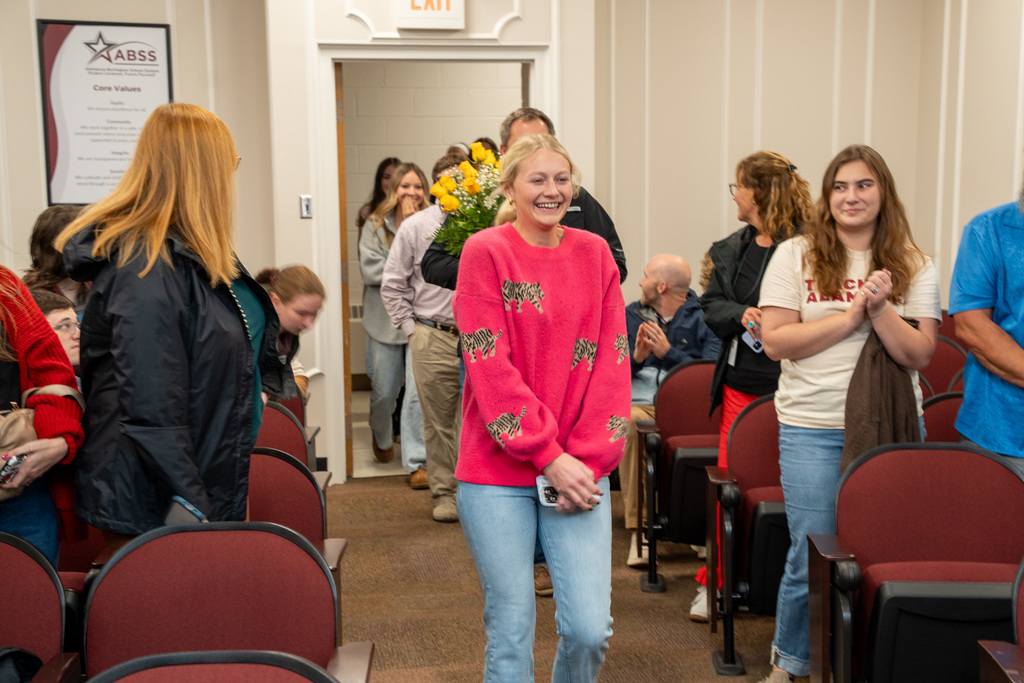 Family of Board Chair Sandy Ellington-Graves make their way down the aisle in the Board auditorium.