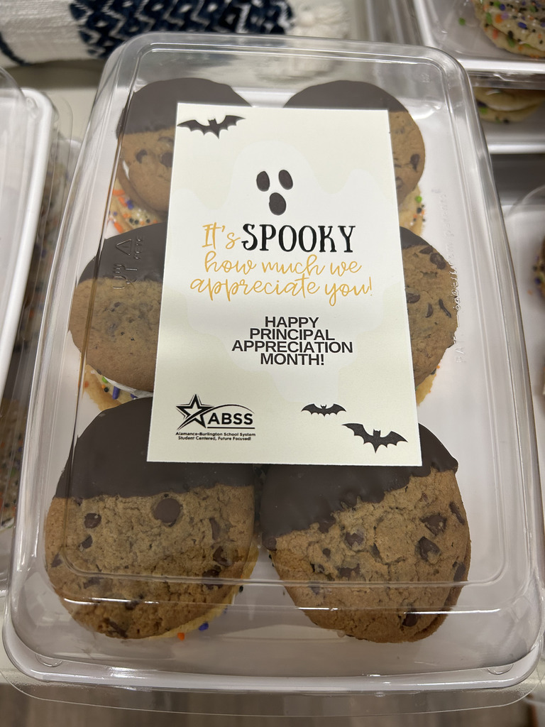 A clear container of cookies with a sticker celebrating principals