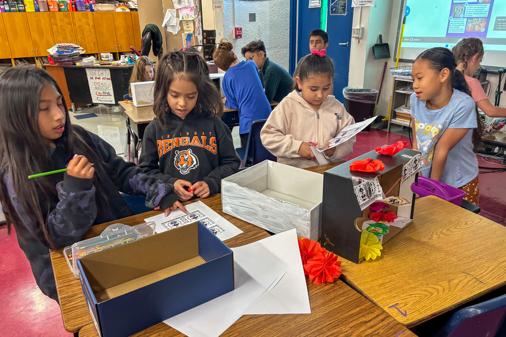 Second grade students creating ofrendas in a classroom for a Day of the Dead project