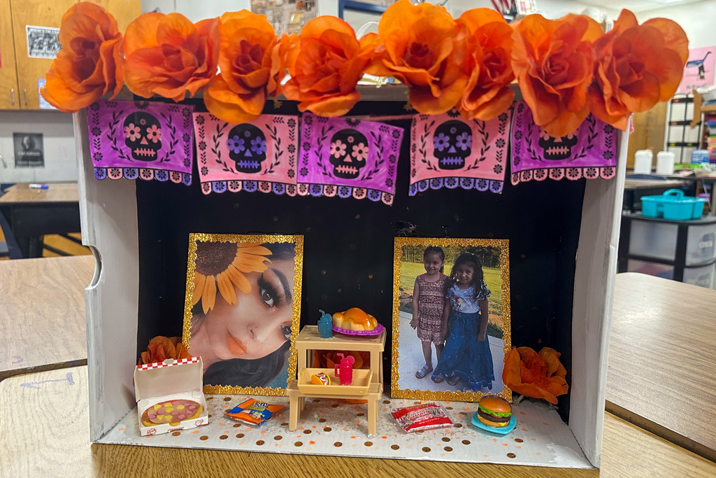 A vibrant ofrenda with a portrait of a person on the left and two little girls on the right