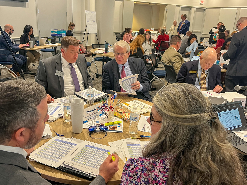 ABSS Superintendent Dr. Fleming and other district representatives engaged in discussion at a roundtable work session, reviewing AP program data and materials with educators from other North Carolina school districts.